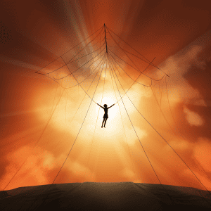Silhouette of a man hanging from a rope.